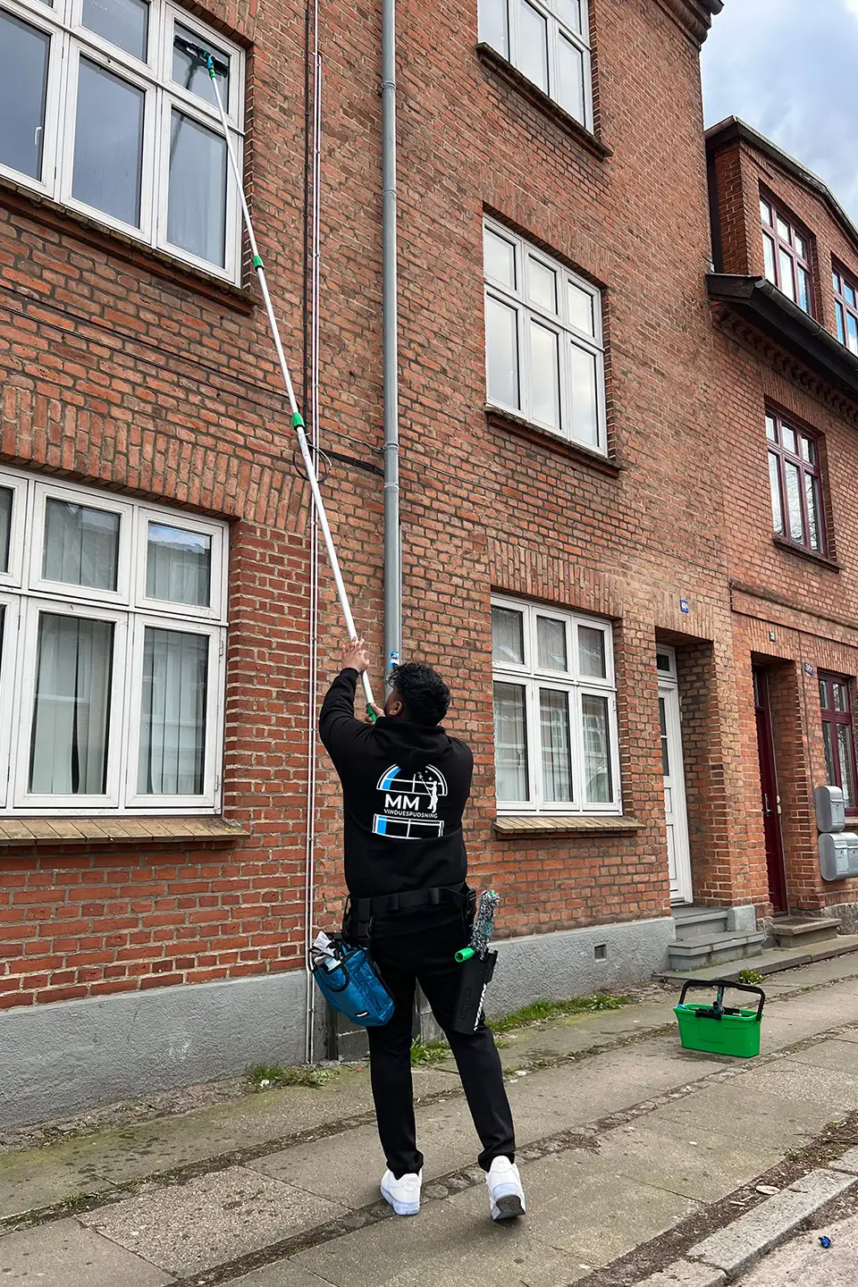 Morten fra MM Multipartner pudser vinduer på 1. sal
