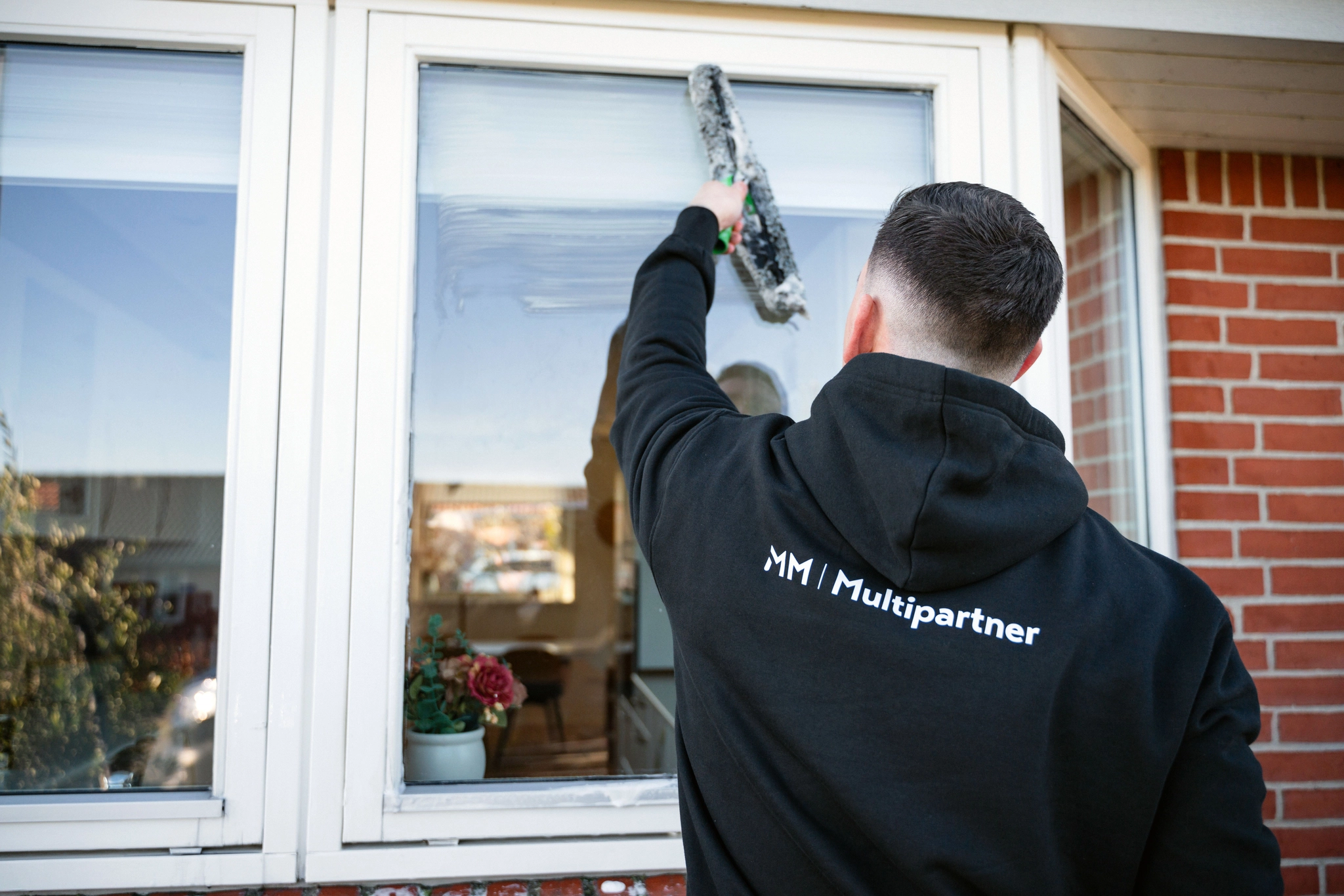 Mathias fra MM Multipartner under en vinduespudsning